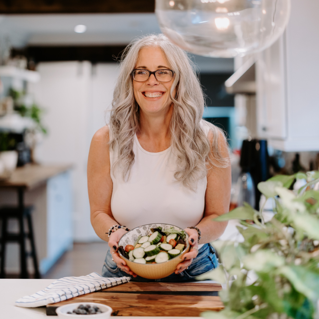 Dawne Sullivan holding salad bowl smiling at the camera