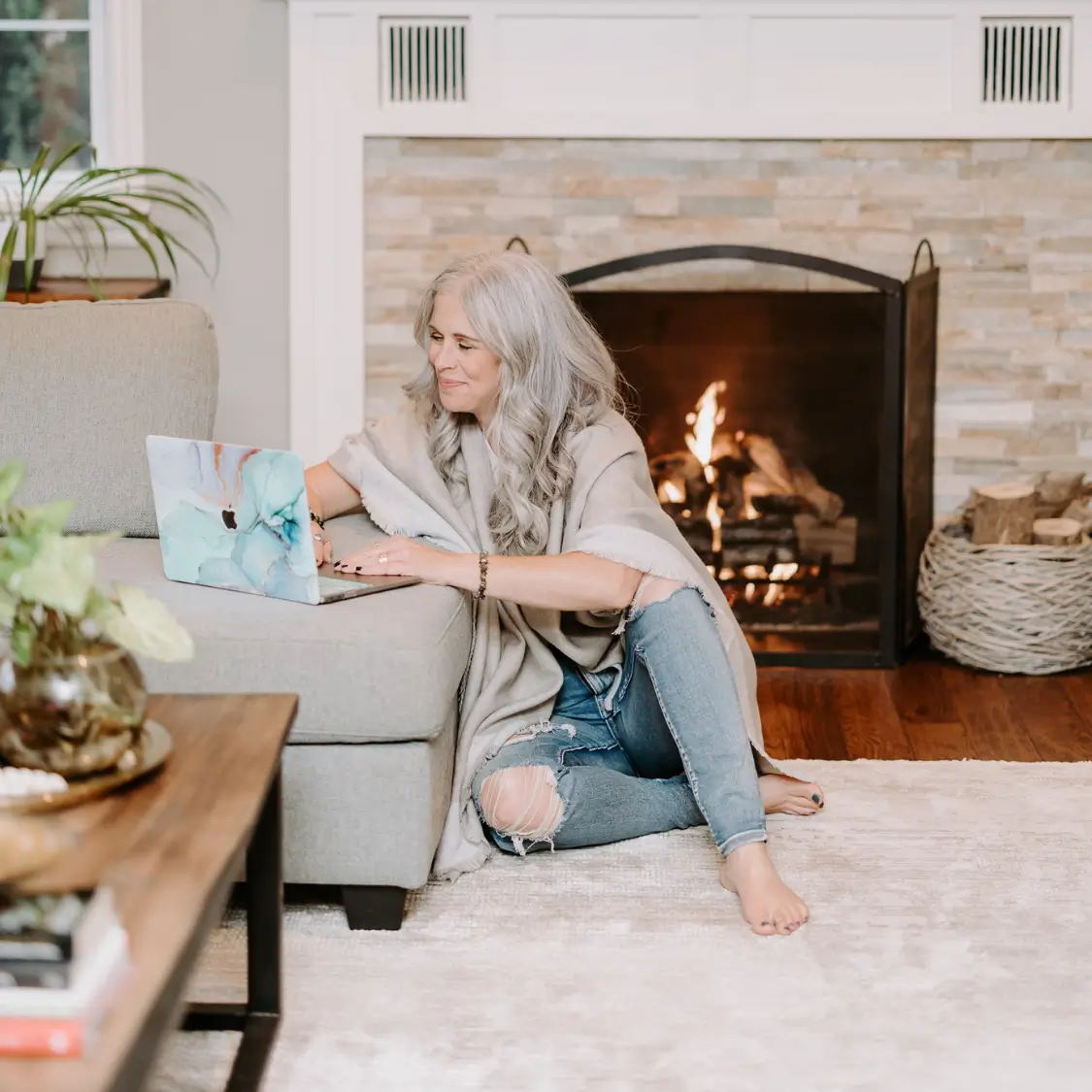 Dawne Sullivan, Holistic Nutritionist, Reiki Master, Cold Immersion Coach, Breathwork Facilitator in front of computer sitting on the ground at home